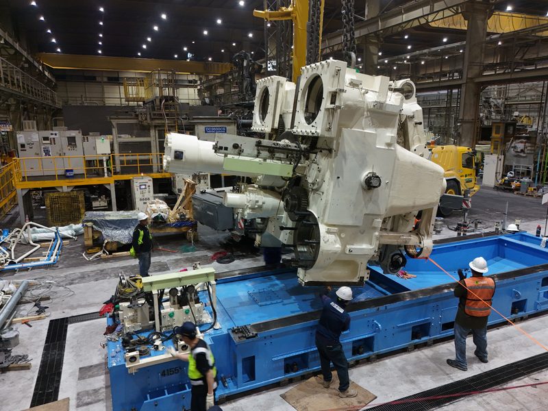 A module lowered towards the machine bed.