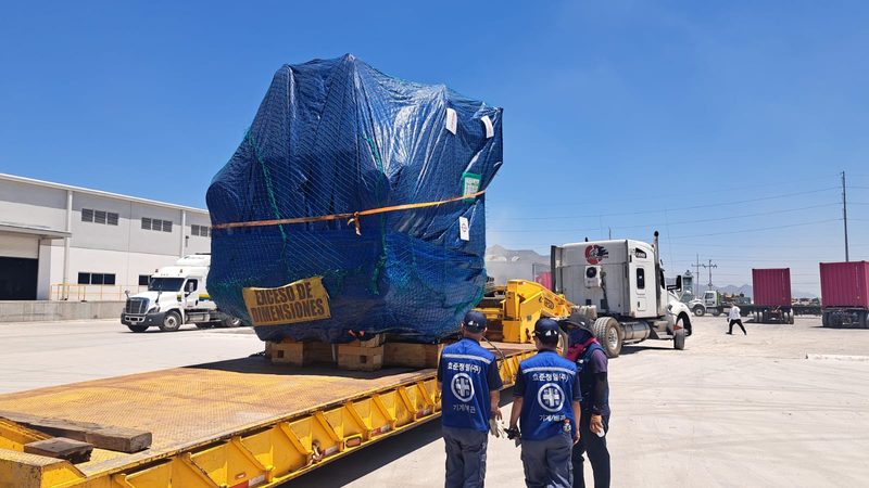 An oversize package on the lowboy, waiting to come in.